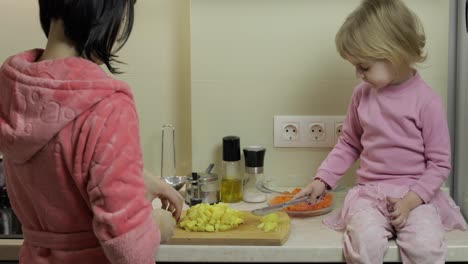 Cute-small-girl-cooking-with-her-mother.-Little-daughter-with-mother-together