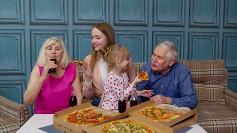 Glückliche-Familie,-Die-Eine-Mittagsparty-Veranstaltet,-Sich-Gegenseitig-Mit-Pizza-Füttert,-Lacht-Und-Gemeinsam-Zu-Hause-Isst