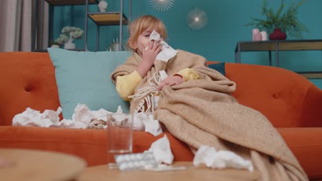 Niña-Con-Cuadros-Que-Sufre-De-Coronavirus-O-Alergia,-Estornuda-Mocos-En-Una-Servilleta-En-El-Sofá-De-Casa
