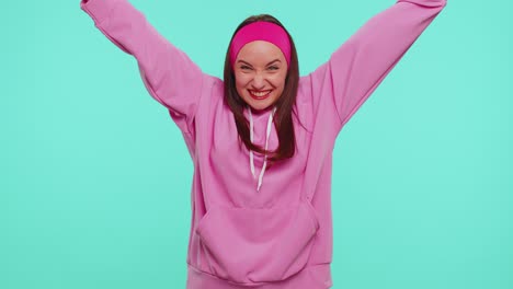 Teen-girl-in-pink-hoodie-shouting,-raising-fists-in-gesture-I-did-it,-celebrating-success,-winning