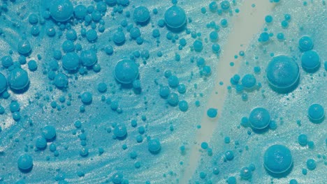 Vista-Superior-Movimiento-De-Gotas-De-Tinta-De-Aceite-Azul-Burbujas,-Fondo-De-Superficie-De-Pintura-Artística-Multicolor