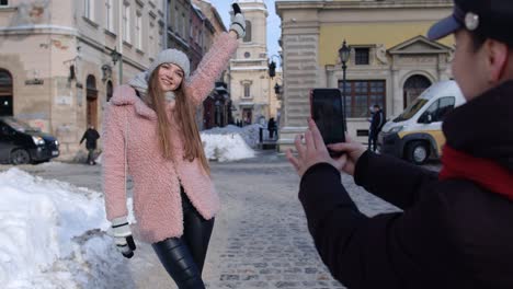 Dos-Jóvenes-Mujeres-Sonrientes-Bloggers-Viajeras-Tomando-Fotos-De-Retratos-En-Teléfonos-Móviles-En-Las-Calles-De-La-Ciudad