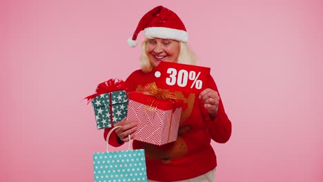 Senior-woman-in-Christmas-sweater-showing-gift-box-and-30-Percent-discount-inscriptions-banner-text