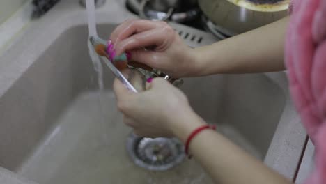 Woman-washing-dishes-in-the-kitchen.-Close-up-of-woman-hand