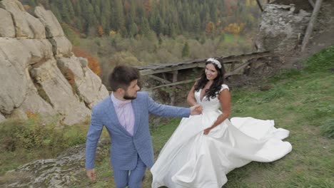 Groom-walking-with-bride-on-a-mountain-hills-in-the-forest.-Wedding-couple