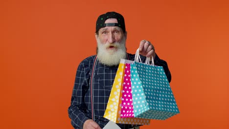 Elderly-bearded-man-showing-shopping-bags-and-Up-To-70-Percent-Off-inscriptions-text,-Black-Friday