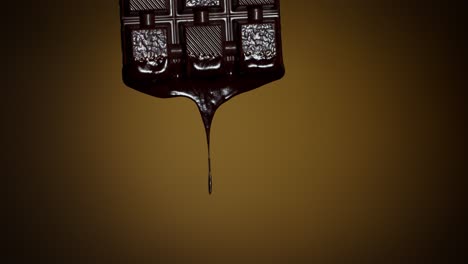 Slow-motion-of-chocolate-bar-with-melted-dark-chocolate-dripping-flowing-over-brown-background