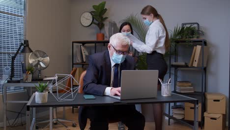 Jefe-Anciano-Con-Máscara-Médica-Trabajando-En-Una-Computadora-Portátil-En-La-Oficina-Durante-La-Pandemia-Del-Coronavirus