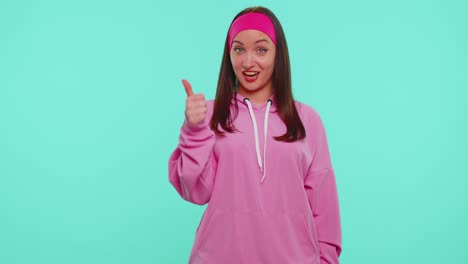 Teen-stylish-girl-in-pink-hoodie-showing-thumbs-up-and-nodding-in-approval,-successful-good-work