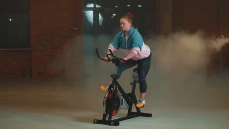 Healthy-Caucasian-woman-exercising-workout-on-stationary-cycling-machine-bike-in-gym,-Slow-Motion