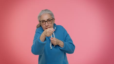 Funny-senior-granny-woman-trying-to-fight-at-camera,-shaking-fist,-boxing-with-expression-punishment