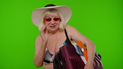 Elderly-grandmother-tourist-waving-hand-hi-hello-welcome,-woman-with-luggage,-passport,-tickets