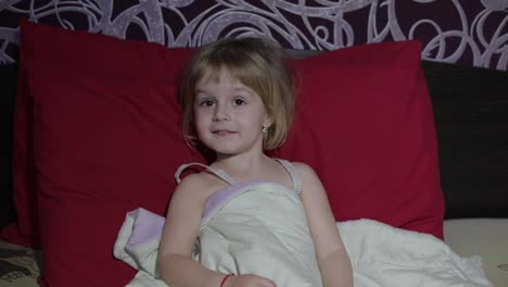 Young-girl-watching-tv-television-on-the-bed