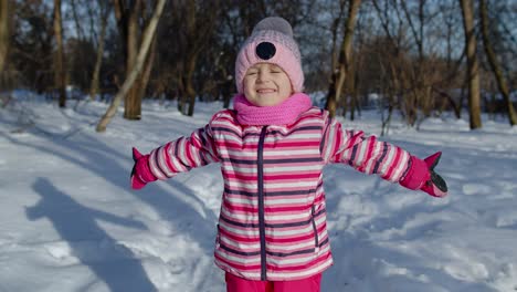 Smiling-child-kid-looking-at-camera,-embracing,-fooling-around,-hugging-in-winter-snowy-park-forest