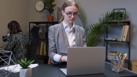 Young-business-woman-freelancer-concentrated-developing-new-project-while-looking-on-laptop-screen