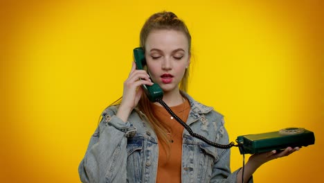 Cheerful-teen-girl-secretary-talking-on-wired-vintage-telephone-of-80s,-says-hey-you-call-me-back