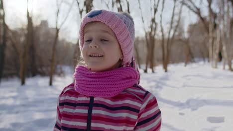 Smiling-child-kid-girl-tourist-walking,-having-fun-on-snowy-road-in-winter-sunny-park-forest,-sunset