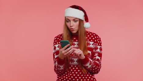 Adult-girl-in-Christmas-sweater-looking-smartphone-display-sincerely-rejoicing-win-success-luck