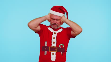 Man-in-Christmas-t-shirt-covering-ears-and-gesturing-no,-avoiding-advice-ignoring-unpleasant-noise