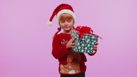 Lustiges-Kleinkind-Mädchen-Trägt-Neujahrspullover-Und-Bekommt-Geschenk,-Interessiert-Sich-Für-Das,-Was-Sich-In-Der-Geschenkbox-Befindet