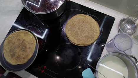 Der-Prozess-Des-Kochens-Hausgemachter-Pfannkuchen.-Frau-Legt-Pfannkuchen-Von-Der-Pfanne-Auf-Den-Teller