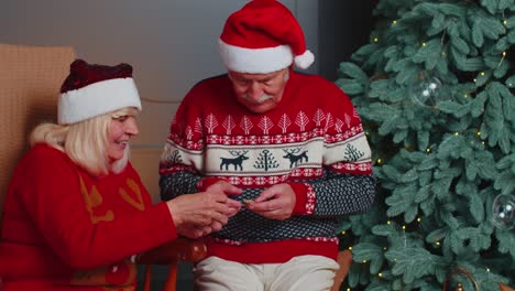 Senior-couple-holding-money-BTC-bitcoins-for-Christmas-gifts,-cryptocurrency-future-technology