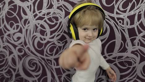 Un-Niño-Feliz-Bailando-En-El-Sofá-Y-Escuchando-Música-Con-Auriculares-En-Casa