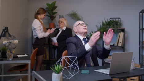 Mature-elderly-freelancer-man-praying-to-God,-looking-upward-and-making-wish-good-luck-in-office