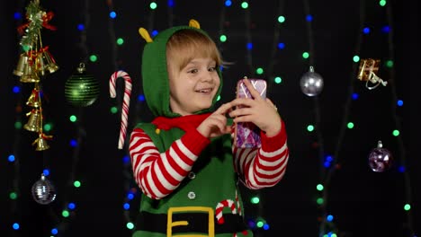 Kind,-Mädchen,-Weihnachtself,-Weihnachtsmann-Helfer-Tippt-Etwas-Auf-Dem-Mobiltelefon-Und-Surft-Gerne-In-Sozialen-Medien