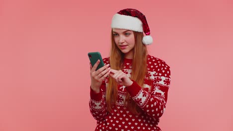 Erwachsenes-Mädchen-Im-Roten-Weihnachtspullover-Schaut-Auf-Smartphone-Display-Und-Freut-Sich-Aufrichtig-über-Erfolg-Und-Glück