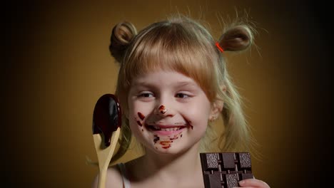 Niña-Sonriente-Alegre-Con-La-Cara-Sucia-De-Chocolate-Derretido-Sobre-Fondo-Oscuro-En-El-Estudio