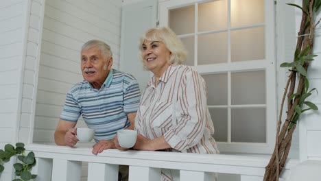 Älteres-Paar-Trinkt-Kaffee-Und-Umarmt-Sich-Während-Der-Coronavirus-Quarantäne-Auf-Der-Veranda-Zu-Hause