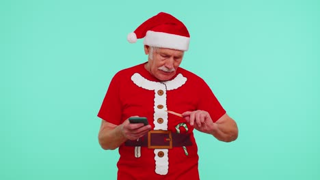 Mature-Christmas-grandfather-man-use-mobile-cell-phone,-plastic-credit-bank-card,-win-calebrate,-wow