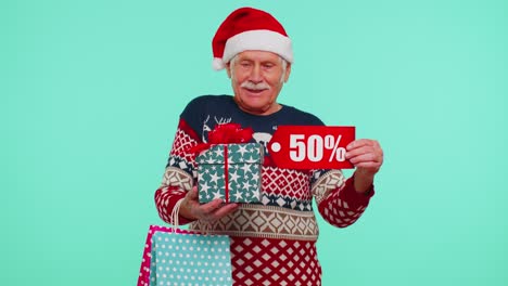 Elderly-man-in-Christmas-sweater-showing-gift-box-and-50-Percent-discount-inscriptions-banner-text
