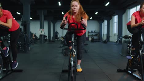 Sportliche-Frauengruppe,-Die-Auf-Einem-Stationären-Spinning-Fahrrad-Trainiert,-Im-Fitnessstudio,-Gewichtsverlust-Im-Innenbereich