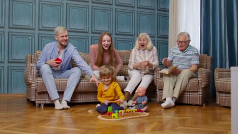Mehrgenerationen-Familienfreizeit-Zu-Hause,-Motivierendes-Geschrei-An-Kind,-Mädchen,-Das-Eisenbahnspielzeug-Spielt