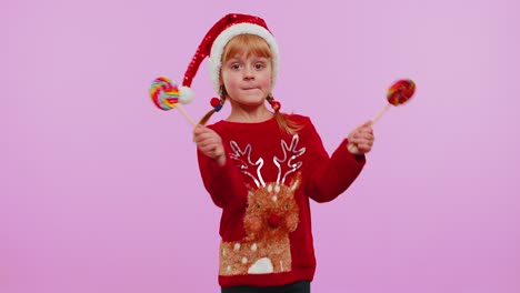Fröhliches-Mädchen-Im-Weihnachtspullover,-Hut-Mit-Gestreiften-Lutschern-In-Der-Hand,-Tanzt-Und-Macht-Alberne-Gesichter