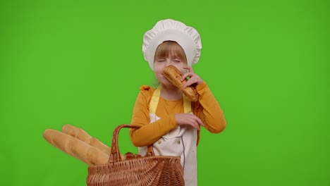 Child-girl-chef-showing-basket-with-baguette-and-bread,-smiling,-sniffing,-eating-bun-with-cream