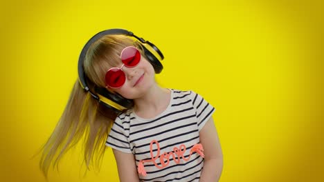 Funny-playful-blonde-kid-child-girl-listening-music-via-headphones,-dancing-disco-fooling-having-fun