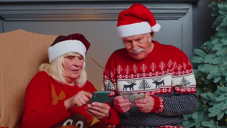 Happy-senior-family-on-mobile-phone-buy-Christmas-presents-doing-online-ecommerce-shopping-purchase