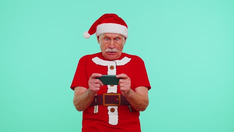 Worried-grandfather-in-Christmas-t-shirt-enthusiastically-playing-racing-video-games-on-mobile-phone