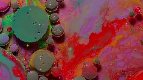 Burbujas-De-Tinta-Mezcladas-Con-Sustancia-Líquida-De-Aceite,-Leche,-Jabón,-Pintura-Acrílica-Brillante-Sobre-Una-Superficie-Colorida