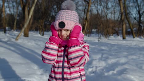 Child-girl-opening-her-mouth-in-amazement,-wow-delight-gesture,-pleasantly-surprise-in-winter-park