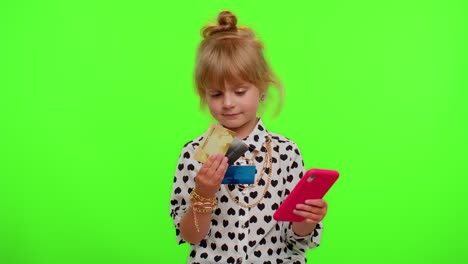 Little-teen-kid-child-girl-using-credit-bank-cards-and-smartphone-while-purchases-online-shopping