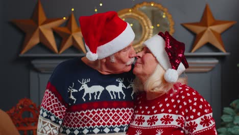 Senior-family-couple-grandmother-grandmother-kissing,-looking-at-camera,-celebrating-Christmas-home