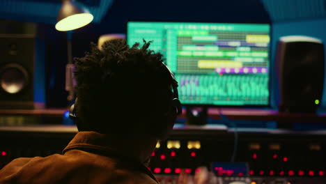 African-american-tracking-engineer-processing-and-mixing-sounds-in-control-room