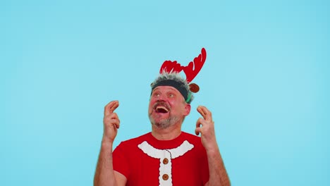Cheerful-man-in-t-shirt-Santa-Christmas-hat-getting-present-gift-box,-expressing-amazement-happiness