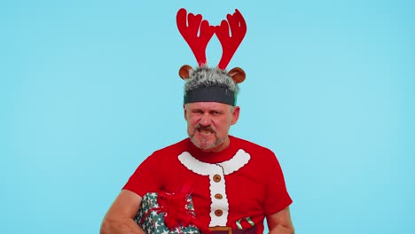 Upset-angry-man-in-Christmas-deer-antlers-raising-hands-in-indignant-expression,-quarreling-conflict