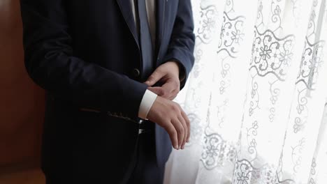 Handsome-groom-fixes-his-jacket.-Wedding-morning.-Businessman.-Slow-motion