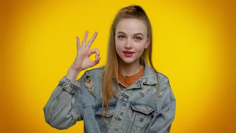 Teen-stylish-girl-looking-approvingly-at-camera-showing-ok-gesture-like-sign-positive-something-good